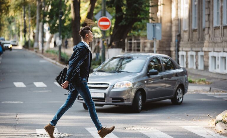 En man korsar vägen och tackar föraren.