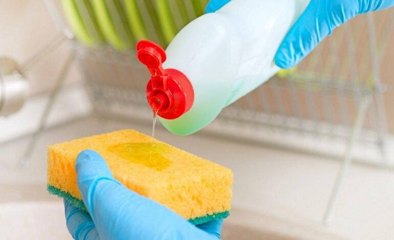 häller tvättmedel på en svamp