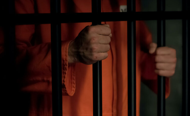 Den dömde sitter bakom galler.